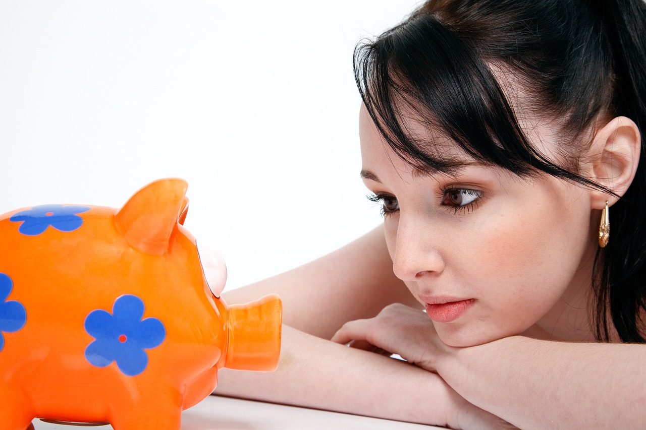 girl staring at piggy bank